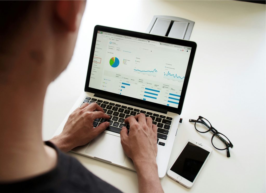 Persona analizando gráficos y datos en un portátil, representando el análisis del mercado eléctrico