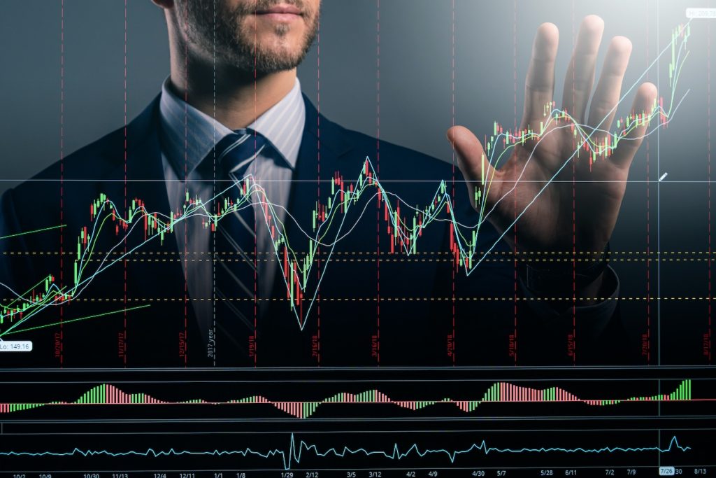 Hombre de negocios interactuando con gráficos de curvas de precios en un mercado financiero